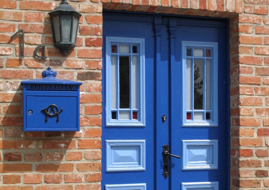 Blau lackierte Haustür an Backsteinfassade
